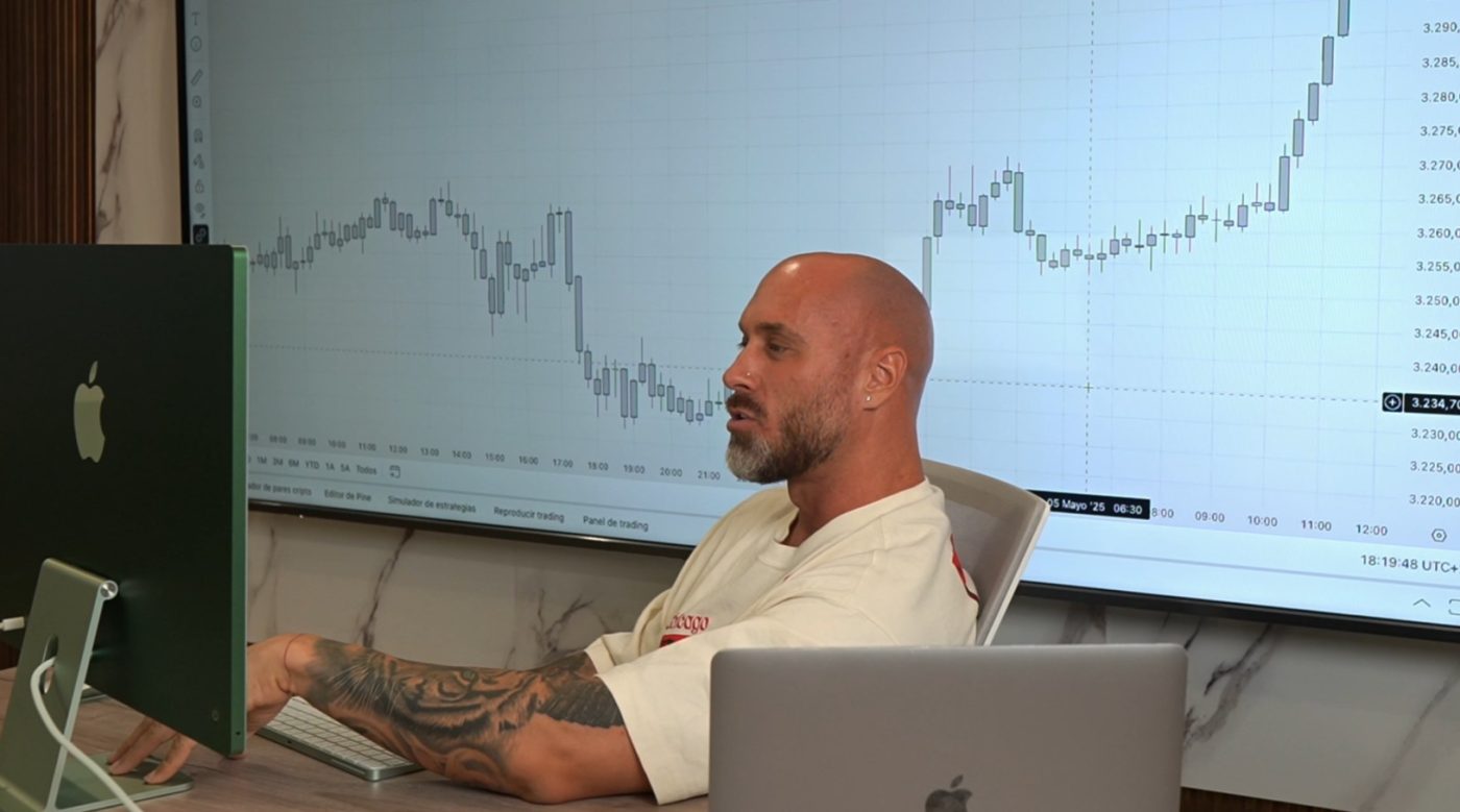 Hombre analizando gráficos de trading en una oficina moderna.