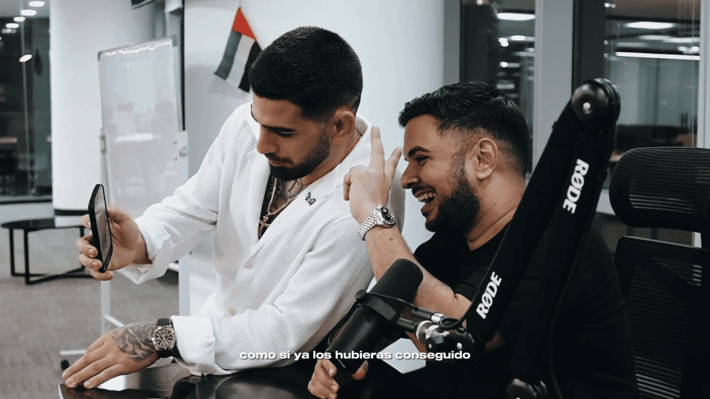 Dos hombres en oficina analizando gráficos y estrategias de trading.