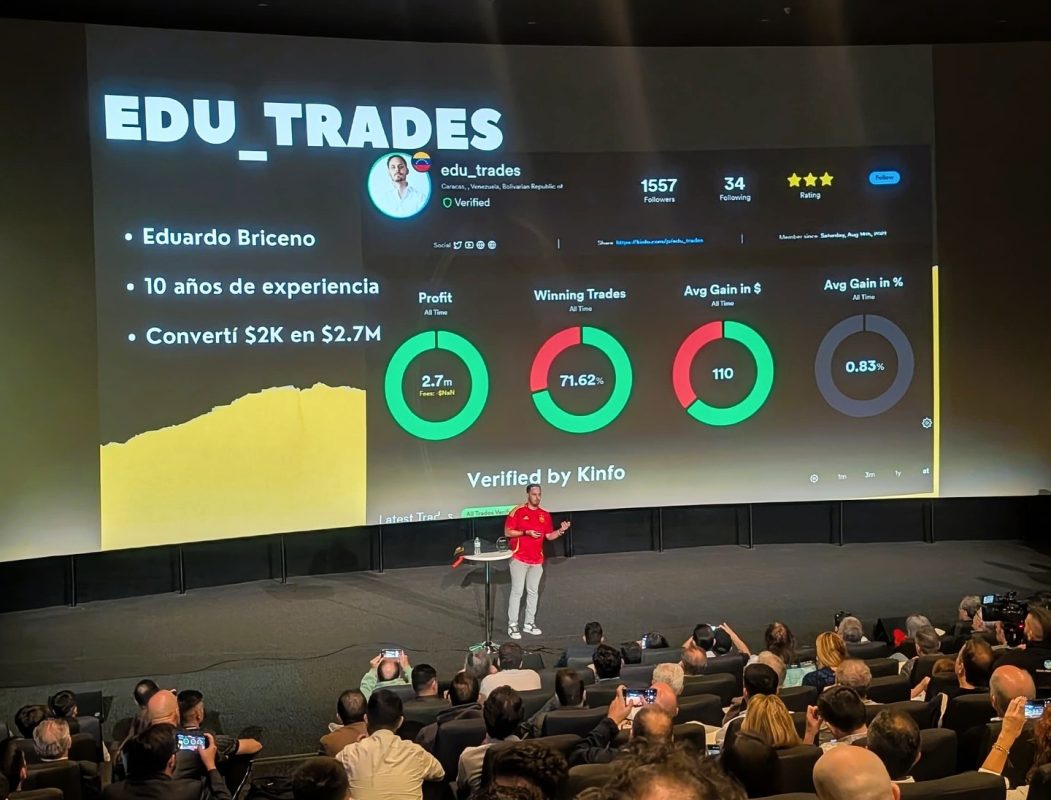 Conferencia sobre trading y educación financiera con presentador en escenario.
