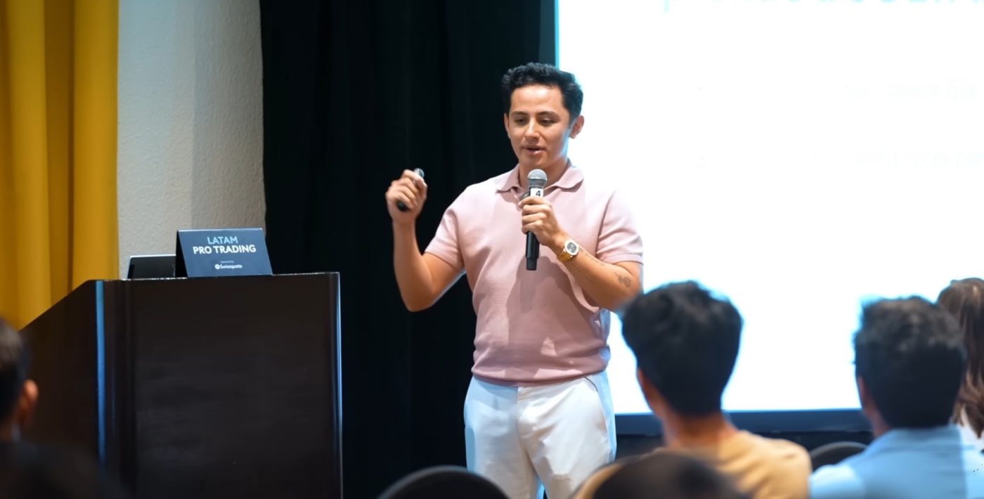Instructor dando una charla sobre trading en un seminario financiero.