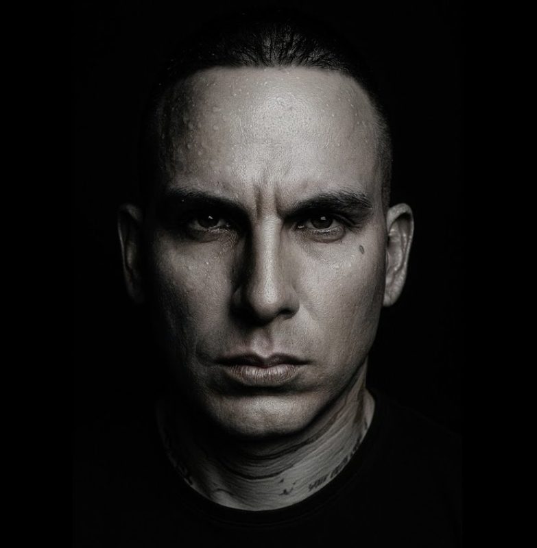 Retrato en blanco y negro de un hombre con expresión seria y mirada intensa.