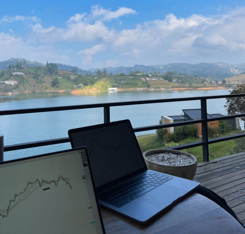 Estación de trading con vista panorámica al río y montañas.
