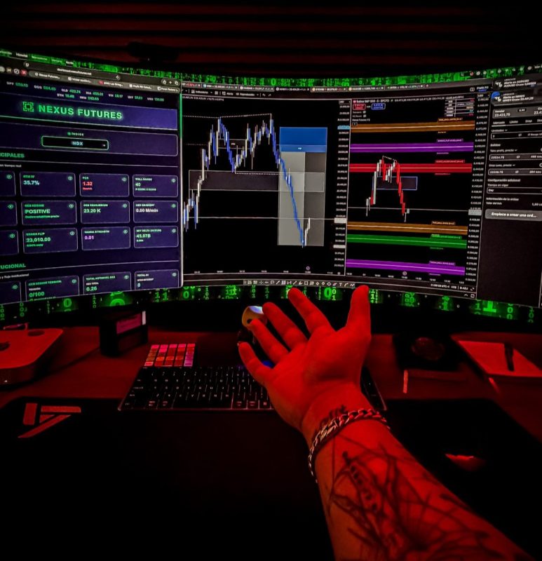 Operador analizando gráficos de trading en múltiples pantallas.